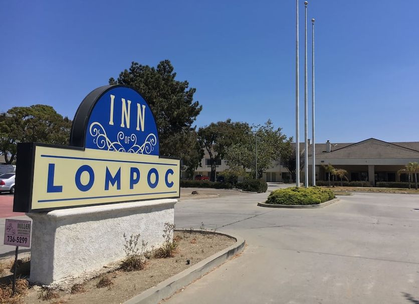 Inn of Lompoc sign at hotel entrance in Lompoc with driveway and building