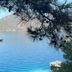 Dedeminn Marina Hotel in Göcek with harbor view, sailboat on calm blue water, and pine-framed coastline