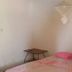 Oudja Hotel in Cap Skirring guest room with bed, pink pillows and small side table