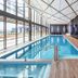 Meriton Suites Canberra indoor pool with floor-to-ceiling windows and lounge chairs in Canberra