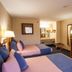 Downtowner Inn and Suites Houston room with two beds, TV, desk and vanity area
