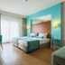 Terrace Elite Resort in Side: bright twin room with turquoise accents, desk, sofa, balcony doors and brick wall