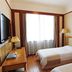 Xing Rong Business Hotel room in Daqing with two single beds, window curtains, and TV