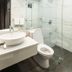 Lenox Hotel Dagupan City bathroom with glass shower, white vessel sink, and toilet