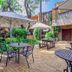Sunward Park Guest House & Conference Centre in Boksburg courtyard with tables, umbrellas and lush greenery