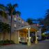 Homewood Suites by Hilton Bonita Springs Naples North exterior at dusk with palm trees and lit entrance in Bonita Springs
