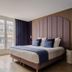 1.75 Paris La Source hotel room in Paris with a large bed, tall arched headboard, and balcony doors
