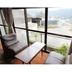 Minshuku Unagi Kohan in Ibusuki with lounge chairs by floor-to-ceiling windows and lake view
