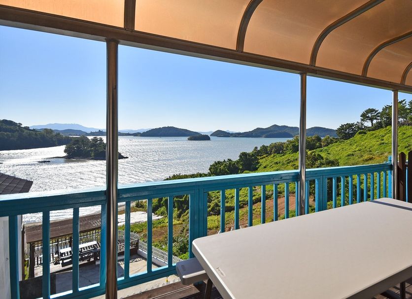 Yeosu Good Morning Pension terrace with table, blue railing, and panoramic sea and island view in Yeosu