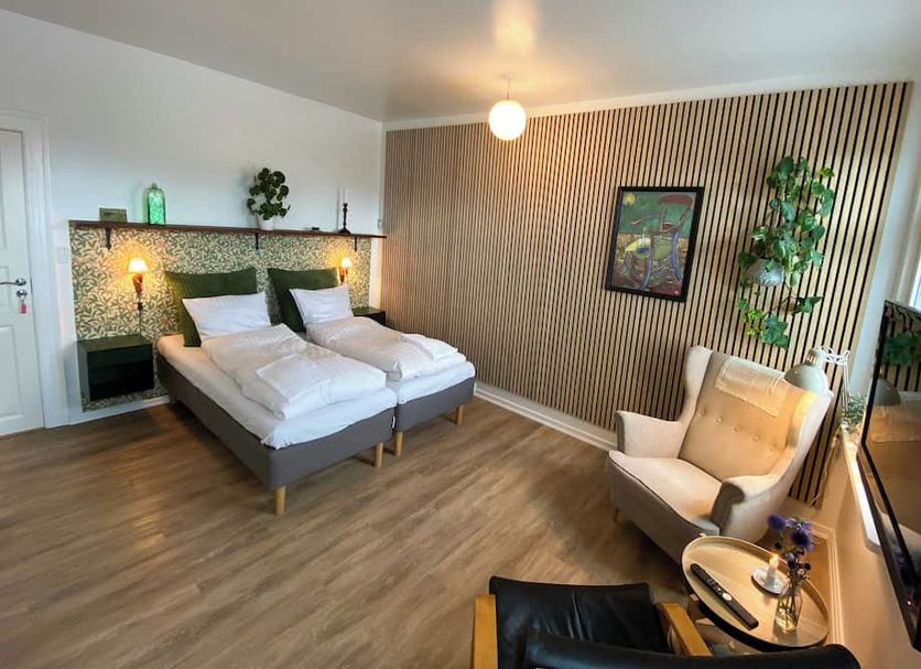 Årslev B&B in Randers guest room with twin beds, armchair, wall-mounted TV and wood floors