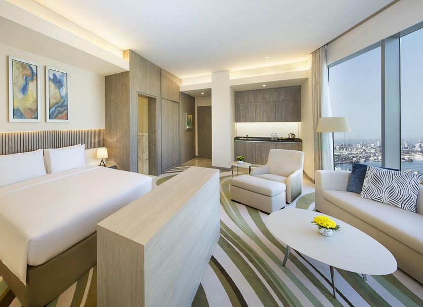 DoubleTree by Hilton Hotel Doha - Old Town room with city view, bed, sofa, and lounge seating