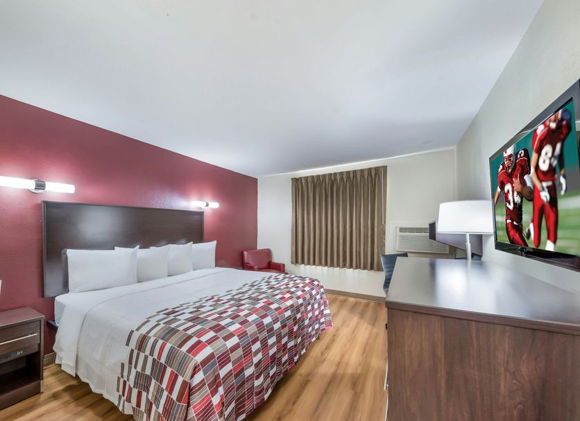 Red Roof Inn & Suites Denton guest room with king bed, desk, and wall-mounted TV in Denton