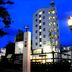 Hotel Ikedaya in Matsumoto, lit exterior at dusk with a tall tower and street lamps