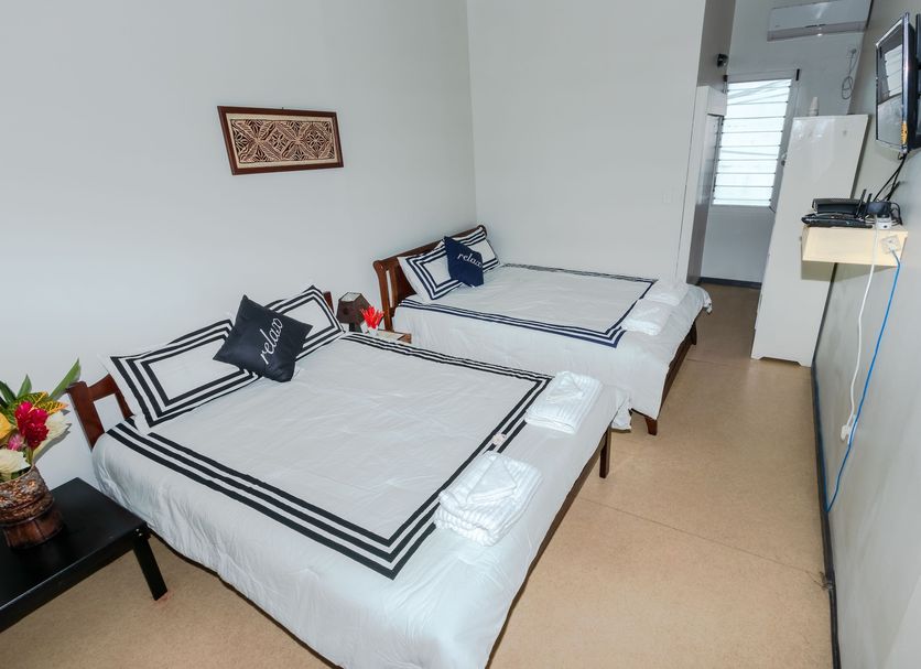 Talofa Inn in Apia: twin room with two single beds, wall-mounted TV, and tiled floor