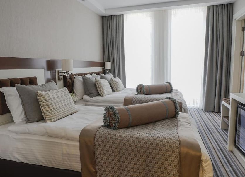 Seven Deep Hotel Ankara guest room with twin beds, pillows, and floor-to-ceiling window curtains
