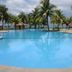 Gem Beach Resort in Kuala Terengganu features a large palm-lined pool by the beach and ocean.