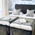 Drottning Victorias Hotell & Vilohem in Borgholm, a twin bed guest room with floral wallpaper and gray bedding