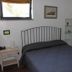 Flegrea House - Casa Rosa guest room in Pozzuoli with bed, window, bedside table and wall art