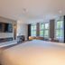 Boutique Hotel Corona, The Hague guest room with large windows, wall TV and electric fireplace