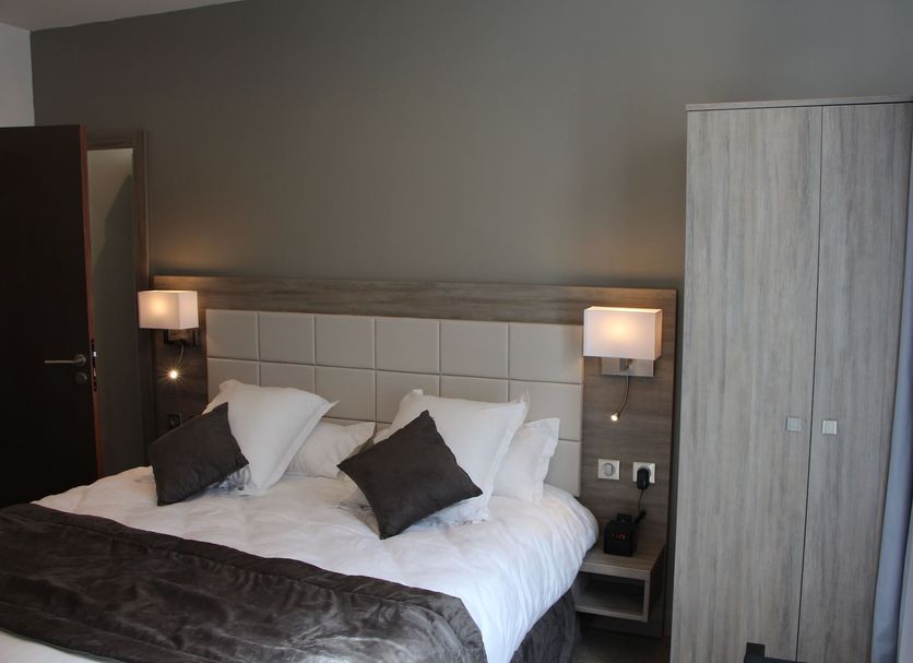 Hotel Restaurant L'esturgeon, Poissy: modern hotel bedroom with king bed, bedside lamps and wardrobe