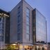 The Preston House and Hotel in Riverhead exterior at dusk with modern glass facade and lit entrance