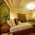 Hotel Ambica Empire Chennai ornate suite with carved ceiling, king bed, TV and peacock wall art