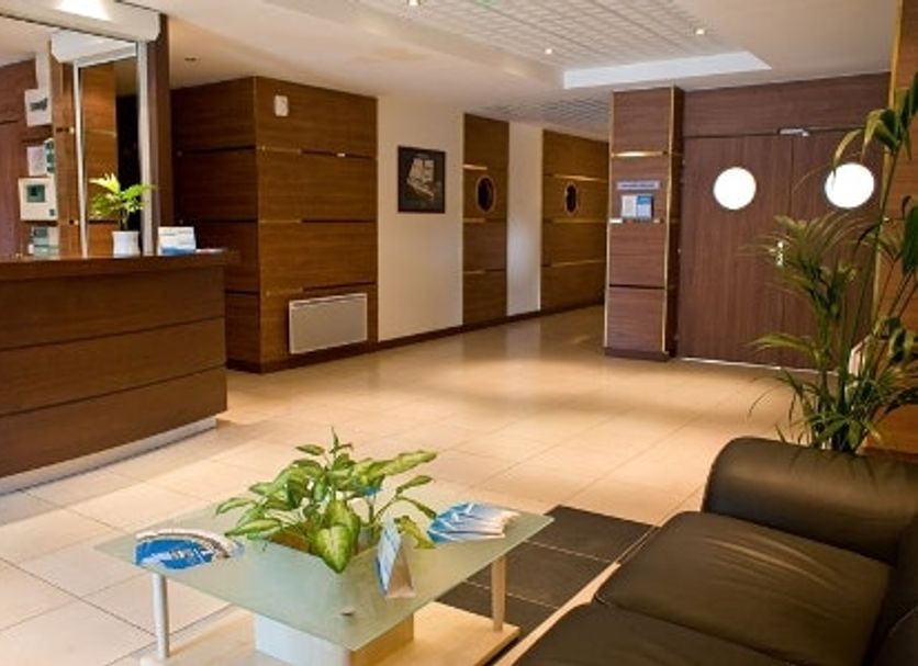 Appart City Le Blanc Mesnil lobby with reception desk, seating area and potted plants in Le Blanc-Mesnil