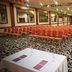 Meeting hall at Anemon Ege Hotel in Izmir with rows of red banquet chairs and a presentation table