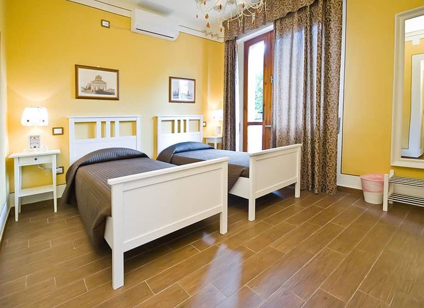 Hotel Pisa Tower in Pisa: twin bedroom with yellow walls, white beds, and balcony door