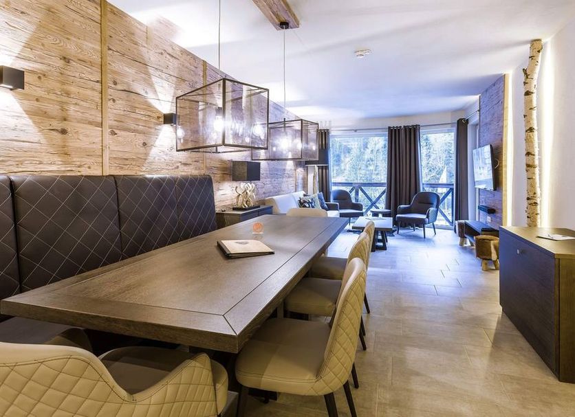Avenida Mountain Lodges Saalbach dining area with long table, quilted chairs and mountain-view seating