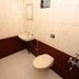 Karthika Residency in Munnar bathroom with wall-mounted sink, toilet, and tiled walls