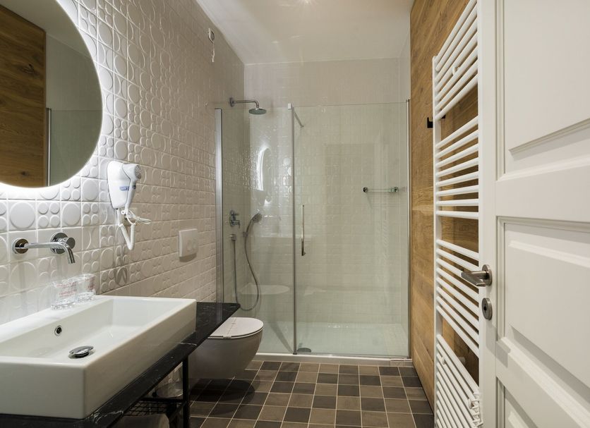 Hotel Peteani Labin bathroom with walk-in shower, wall-hung toilet, vessel sink and heated towel rack