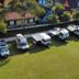 Hotel Vale Verde Penedo in Penedo: camper vans parked beside a green lawn and colorful buildings