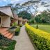 Muthu Lake Naivasha Country Club in Naivasha, cottages along a garden path beside manicured lawns