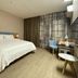 Home Inn Neo Shanghai Pudong Airport room with queen bed, desk, chair and large window curtains