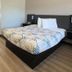 Motel 6 Costa Mesa room with bed, desk, vanity mirror and wood-look flooring