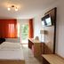 Alpina Löwen Hotel in Sankt Märgen guest room with double bed, desk, balcony doors and wall TV