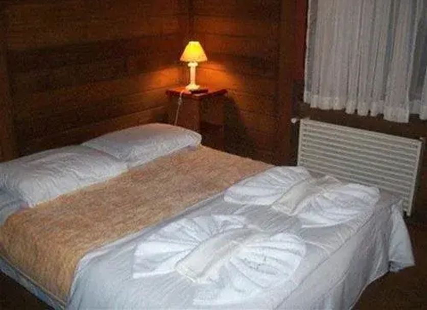 Pousada Raposa Vermelha room in Gramado with a bed, bedside lamp, window and radiator