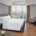 F1 Hotel Manila in Taguig guest room with king bed, city view window, desk and TV