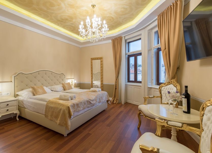 Central Square Heritage Hotel Split room with chandelier, king bed, and large windows