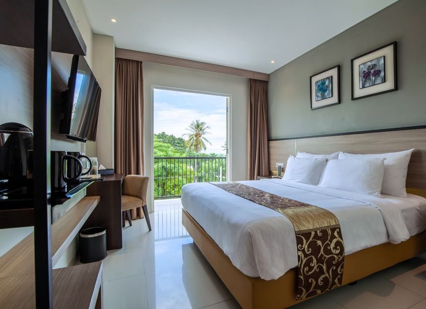 Montana Premier Senggigi guest room with king bed and balcony view of lush greenery