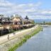 Inn Kawashima in Kyoto overlooking a riverfront promenade and cityscape under a cloudy sky