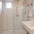 Stössels Hotel in Lüneburg bathroom with walk-in shower, wall mirror, and modern sink