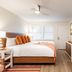 The Beach Club on Madison Avenue in Cape May guest room with bed, kitchenette and sunset wall art