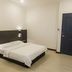 Luna Capsule in Semporna guest room with double bed, wall lights, and dark blue door