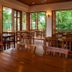 Riverhouse Resort in Mae Sariang dining room with wooden tables, chairs, and forest views