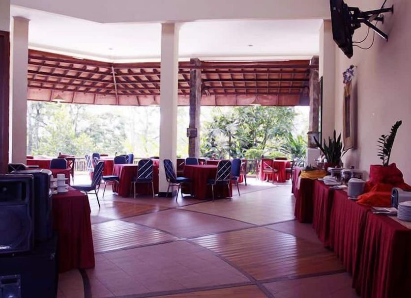 Campago Resort Hotel in Bukittinggi dining area with open-air seating and forest views