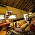 Pilanesberg Private Lodge in Pilanesberg with thatched-roof lounge, sofas and TV inside a spacious lodge