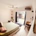 Radio Tulum hotel room in Tulum with king bed, desk, ceiling fan, and balcony doors to patio