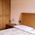 Borcanela Apartments in Moena bedroom with wooden wardrobe, bedside table and double bed